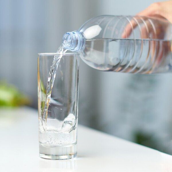 A clear bottle of water on a neutral background